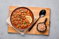 Moroccan Harira Soup in black bowl at grey concrete table top. Harira is Moroccan Cuisine dish. Ramadan Iftar Food