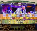 A Moroccan male vendor working at a colorful fruit juice stall in Marrakech Jemaa el-Fnaa Square