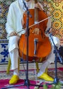 Moroccan musician wearing a djellaba plays the cello