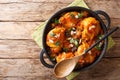 Moroccan recipe Chicken with eggplant, almonds with vegetable gravy close-up in a pan on the table. Horizontal top view