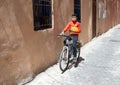 Moroccan schoolboy riding his bicycle home along a narrow street in the medina quarter near Jemaa el-Fnaa Square.