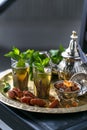 Moroccan tea with mint in traditional glasses, copper teapot on a copper plate