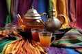 moroccan teapot with colorful tea glasses on patterned cloth