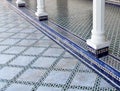 Moroccan tiled floor with white pillars