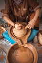 Moroccan woman grinding argan kernels into thick brown oily liquid.