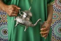 Moroccan woman with henna painted hands pouring tea