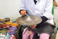 A Moroccan woman paint ceramic souvenir on the rotating table. Fez, Morocco.