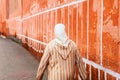 Moroccan woman seen from the back dressed in typical white and red djellaba