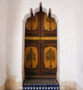 Moroccan wooden painted door set inside a carved plaster doorway