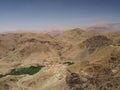 Oasis in desert mountains surrounding