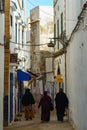 Morocco. Essaouira. Three women dressed in djellaba walk down a street