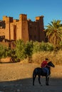 Morocco. Horse rider in front of the village of Ait Ben haddou