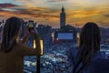 Morocco. Marrakesh. Women taking photo at Place Jemaa el fna at sunset