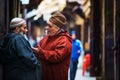 Friend senior people man talk in ancient market of Fes Medina with traditional colorful muslin dress and life style, Fes, Morocco
