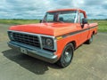 old orange Chevrolet Chevy C 10 pickup truck 1970s by GM parked on an airstrip. Classic car show. Royalty Free Stock Photo