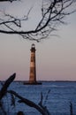 Morris Island Lighthouse in the distance, framed by bare trees a Royalty Free Stock Photo