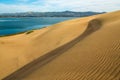 Sand Dunes on the Beach. Blue Water, Blue Sky, and Golden Sand Royalty Free Stock Photo