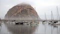 Morro Rock shrouded in early morning fog reflecting in Morro Bay harbor on the Central Coast of California United States Royalty Free Stock Photo