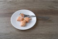 Morsels of salmon on a white plate with a fork Royalty Free Stock Photo