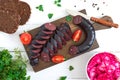 Morsilla - blood sausage. Pieces of Spanish black pudding on a wooden cutting board on white background. Easter menu. The top view Royalty Free Stock Photo