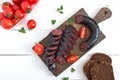 Morsilla - blood sausage. Pieces of Spanish black pudding on a wooden cutting board on white background. Easter menu. The top view Royalty Free Stock Photo