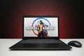 Mortal Kombat 1 game on the screen laptop computer with mouse on black textured wall with red light. Royalty Free Stock Photo