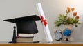 Mortar board with degree paper on wood table.