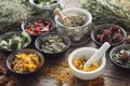 Mortar, bowls and jars of dry medicinal herbs on table. Healing herbs assortment. Royalty Free Stock Photo