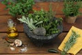 Mortar, different herbs, vegetables and oil on wooden table Royalty Free Stock Photo