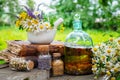 Mortar of healing herbs, bottles of healthy essential oil or infusion and dry medicinal herbs, old books.