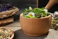 Mortar with healing herbs and pestle on table Royalty Free Stock Photo