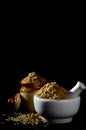 Coriander Powder and seeds with mortar and pestle on black background Royalty Free Stock Photo