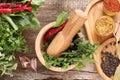 Mortar with pestle, fresh green herbs and different spices on wooden table, flat lay Royalty Free Stock Photo