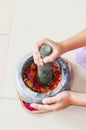 A mortar and pestle or lesung batu in Malay with crushed chilies, fried shallots and shrimp paste mixed together.