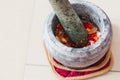 A mortar and pestle or lesung batu in Malay with crushed chilies, fried shallots and shrimp paste mixed together.