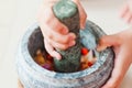 A mortar and pestle or lesung batu in Malay with crushed chilies, fried shallots and shrimp paste mixed together. Royalty Free Stock Photo