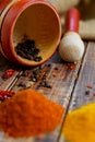 Mortar and pestle with pepper, chili near spices on the wooden table. Royalty Free Stock Photo