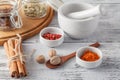 Mortar and pestle with pepper and spices on wooden table Royalty Free Stock Photo