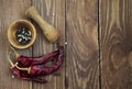 Mortar and pestle with pepper and spices on wooden table Royalty Free Stock Photo