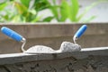 mortar pile on trowels put on a brick block wall in construction site Royalty Free Stock Photo