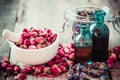 Mortar with rose buds, bottles of tincture and dried flowers Royalty Free Stock Photo