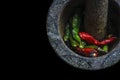 Mortar stone with chilli on fire, top view, on black background Royalty Free Stock Photo