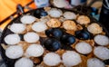 `Kanom Krok` is Thai traditional dessert. Woman hand removing Kanom Krok from stove by spoon. Street food in Thailand.