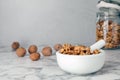 Mortar with walnuts and pestle on marble table Royalty Free Stock Photo