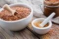 Mortar of whole flax seeds and small mortar of linseeds crushed into powder, glass jar of raw organic paste from flax seed Royalty Free Stock Photo