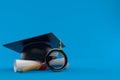 Mortarboard with certificate and magnifying glass