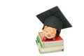 Mortarboard and piggy bank on stack book isolate on white background Royalty Free Stock Photo