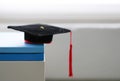 Mortarboard on stack of books in white background