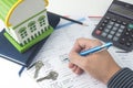 Mortgage application form, top view, house model, notebook, calculator, pen, pencil and key with hand, business mortgage concept Royalty Free Stock Photo