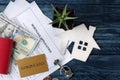 Mortgage application. Key with house keychain and blank and money on a blue wooden table. concept of buying a home. top view